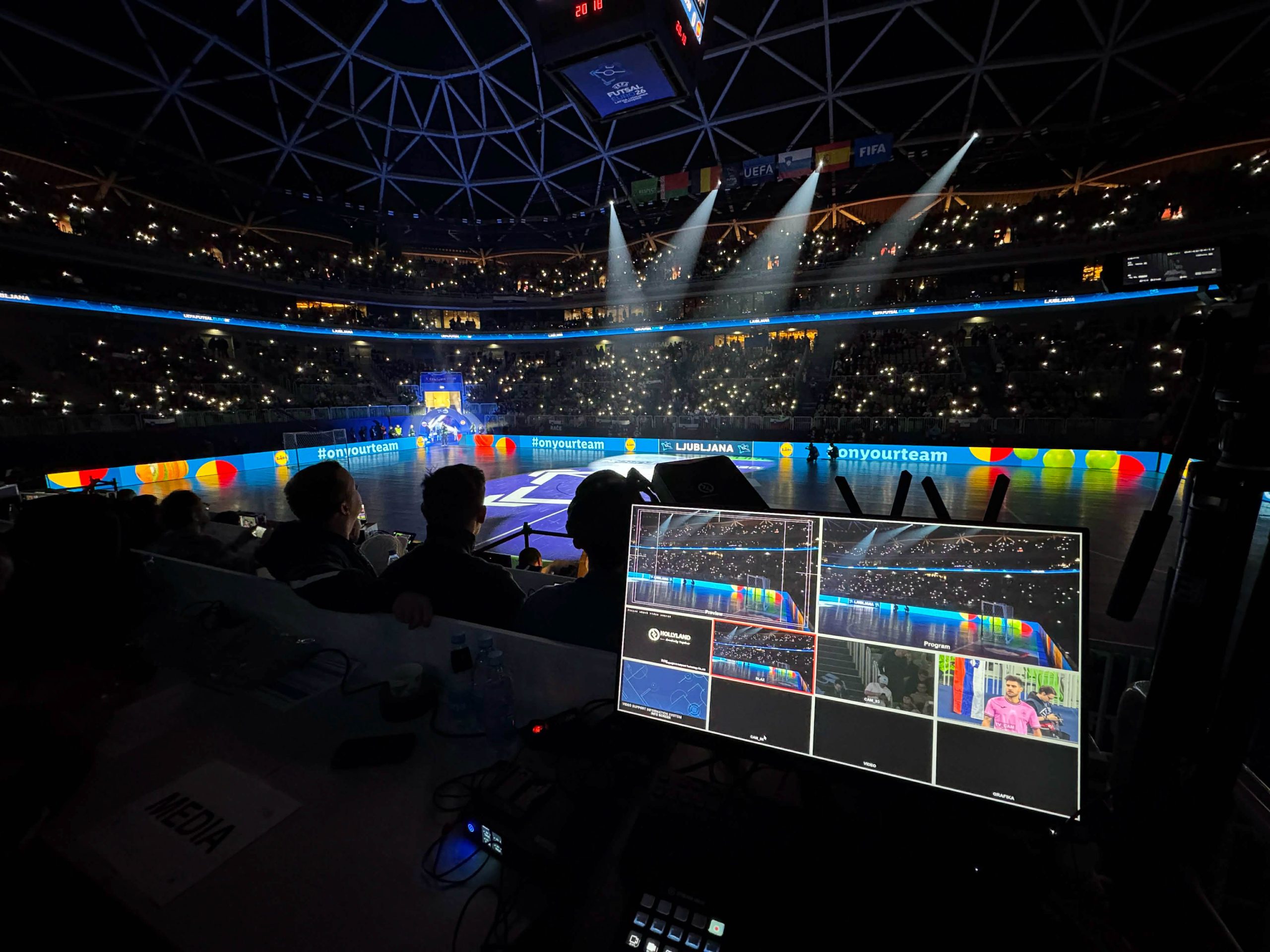 Pogled iz produkcijske režije na polne tribune dvorane z lučkami na Evropskem prvenstvu v futsalu 2026.